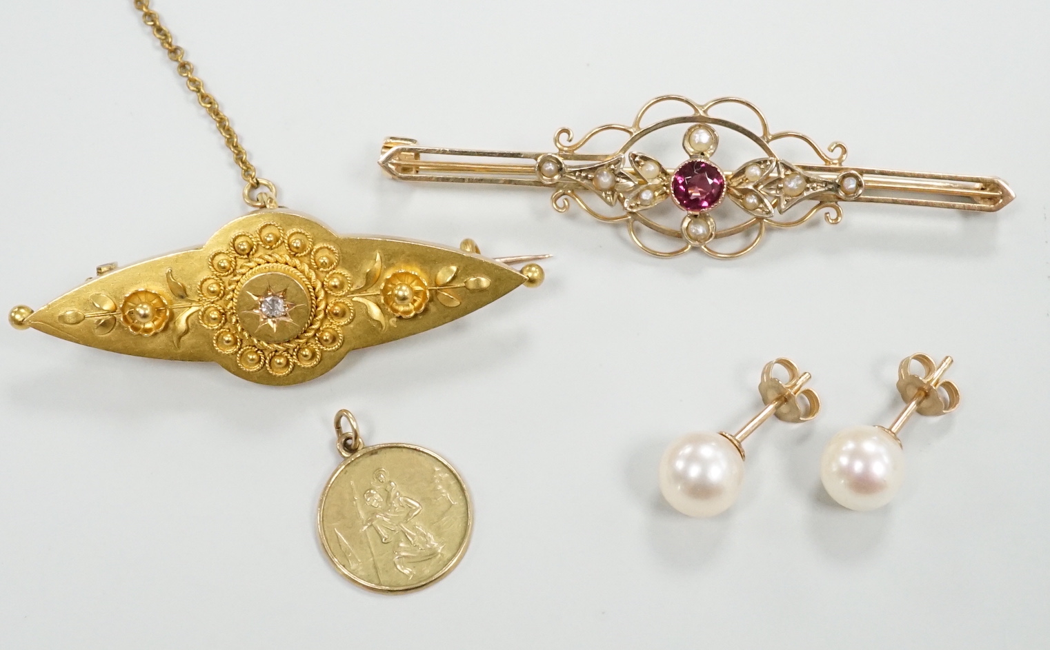 A Victorian 15ct and diamond set brooch, 45mm, a similar 9ct and gem set brooch, a pair of cultured pearl ear studs and a 9ct small medallion.